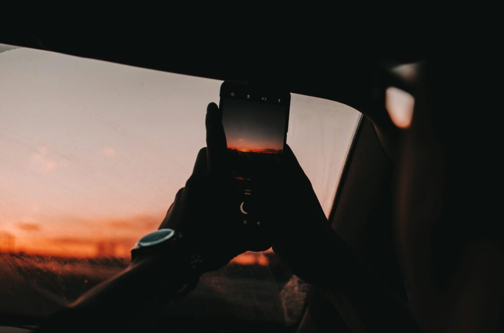 person using smartphone during golden hour